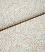 Folded Larkspur Linen Look fabric in cream and soft beige, highlighting its linen-look texture and detailed floral and foliage design.