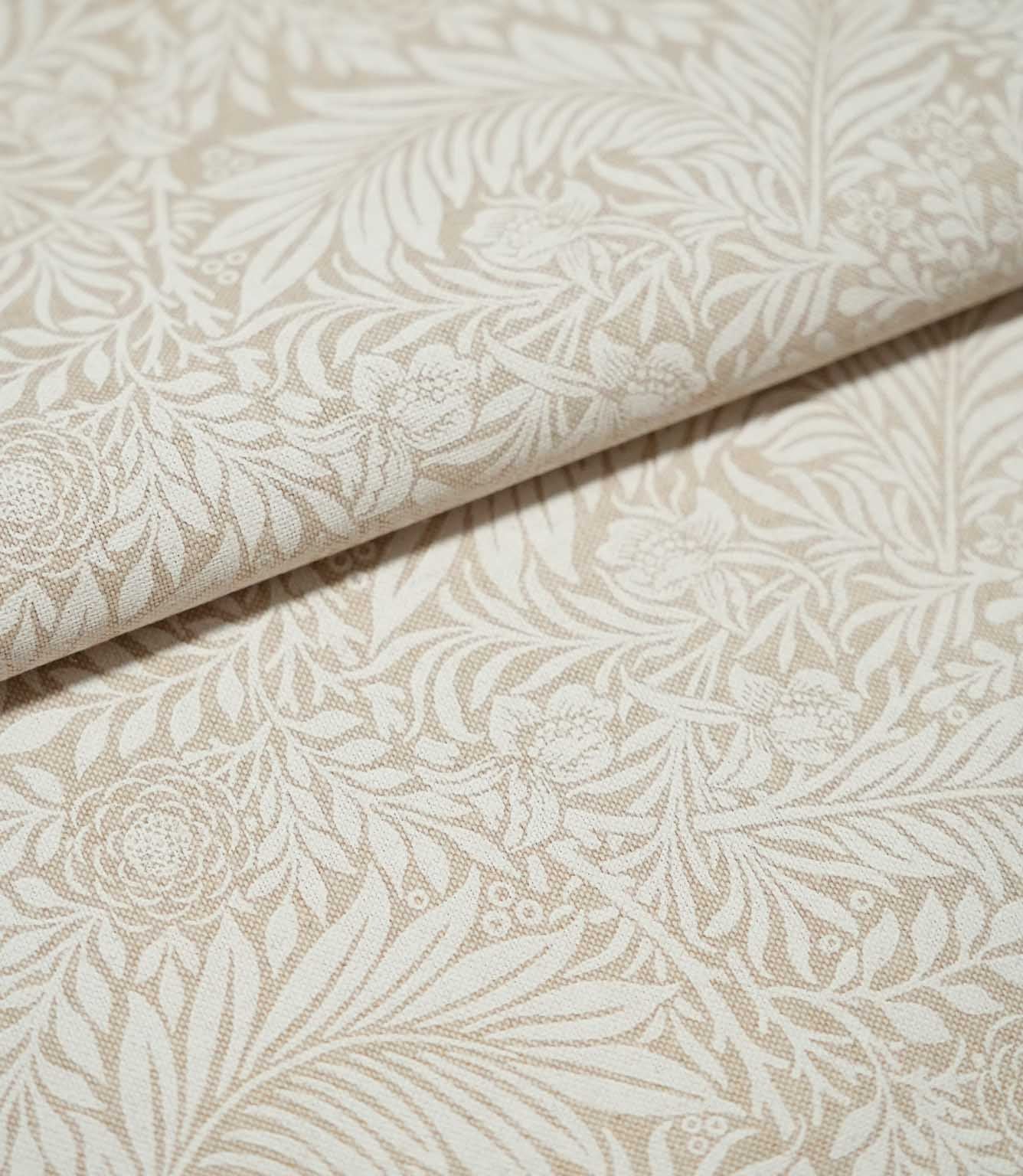 Folded Larkspur Linen Look fabric in cream and soft beige, highlighting its linen-look texture and detailed floral and foliage design.
