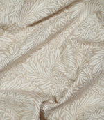 Draped Larkspur Linen Look fabric in cream and soft beige, showing how the contemporary floral and foliage pattern falls naturally through soft folds.