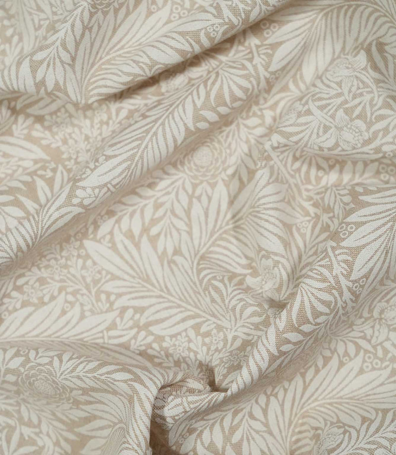 Draped Larkspur Linen Look fabric in cream and soft beige, showing how the contemporary floral and foliage pattern falls naturally through soft folds.