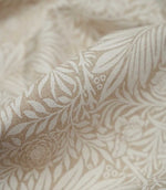 Macro close-up of Larkspur Linen Look fabric in cream and soft beige, highlighting the woven texture and fine leaf and floral detailing.