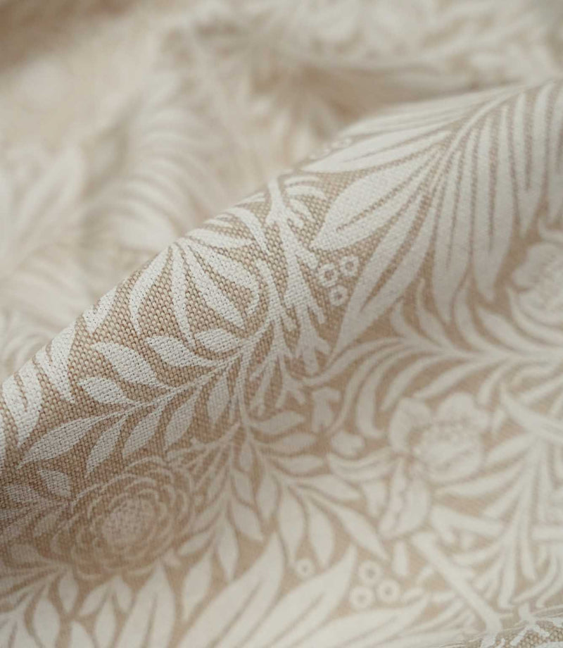Macro close-up of Larkspur Linen Look fabric in cream and soft beige, highlighting the woven texture and fine leaf and floral detailing.