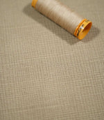 Lois Velvet Oat fabric laid flat with a coordinating beige sewing thread spool, highlighting the warm oatmeal colour, subtle crosshatched texture and fine velvet pile.