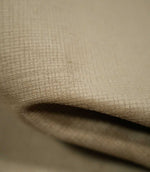Macro photograph of Lois Velvet Oat fabric folded over itself, revealing the soft, short velvet pile, fine crosshatched texture and subtle tonal variations in oatmeal beige.
