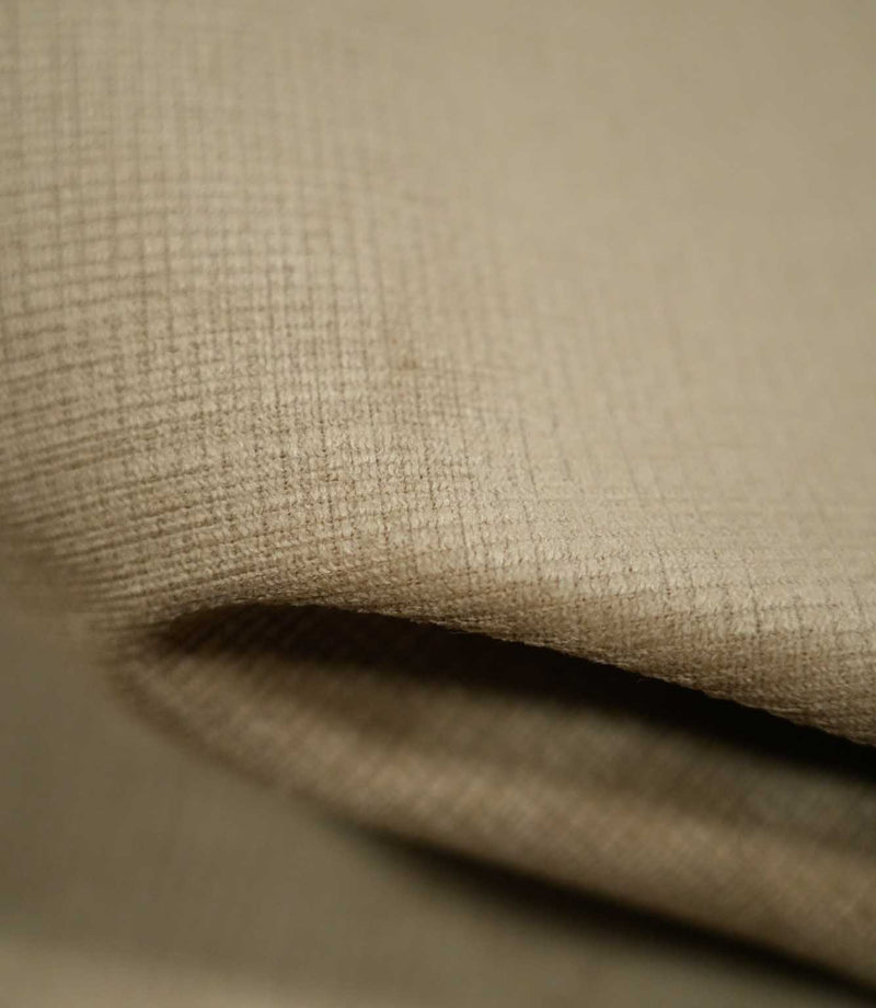 Macro photograph of Lois Velvet Oat fabric folded over itself, revealing the soft, short velvet pile, fine crosshatched texture and subtle tonal variations in oatmeal beige.