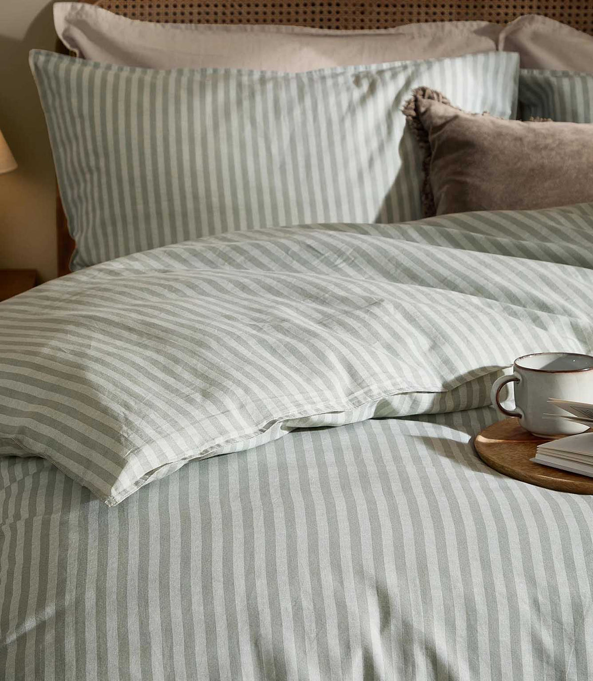 Close-up of Marlow Stripe bedding in Artichoke/Sage showing the soft sage green and off-white vertical stripe across the duvet cover and coordinating pillowcase.