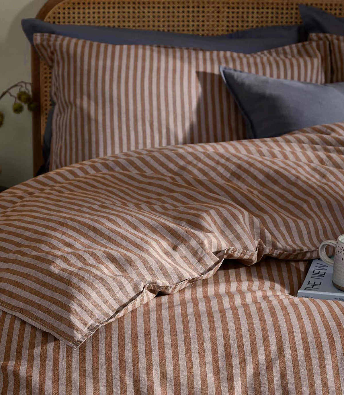 Close-up of Marlow Stripe bedding in Cocoa/Vintage Blue showing the fine cocoa brown and vintage blue striped pattern and softly crumpled fabric texture.