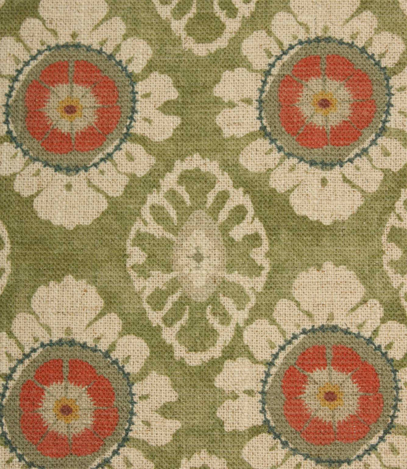 Close-up of olive green floral medallion fabric featuring coral flower motifs, cream petals and soft geometric detailing on a woven natural-look base.