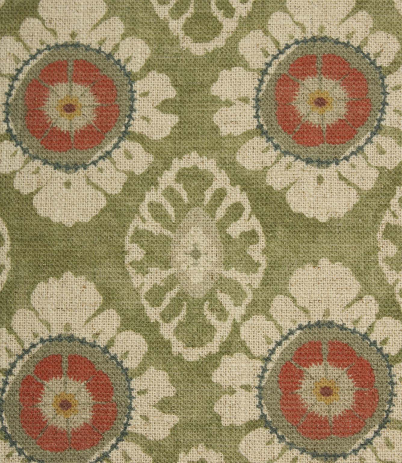 Close-up of olive green floral medallion fabric featuring coral flower motifs, cream petals and soft geometric detailing on a woven natural-look base.