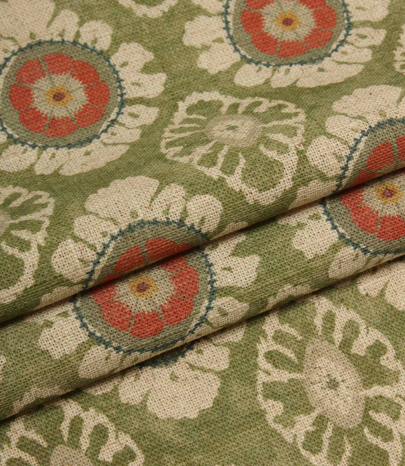 Folded olive green printed fabric showing a soft drape and detailed floral medallion pattern on a textured weave.