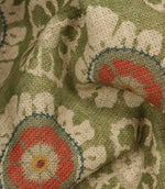 Detailed close-up of woven floral fabric in olive green, cream and coral tones, highlighting the textured linen-look finish.