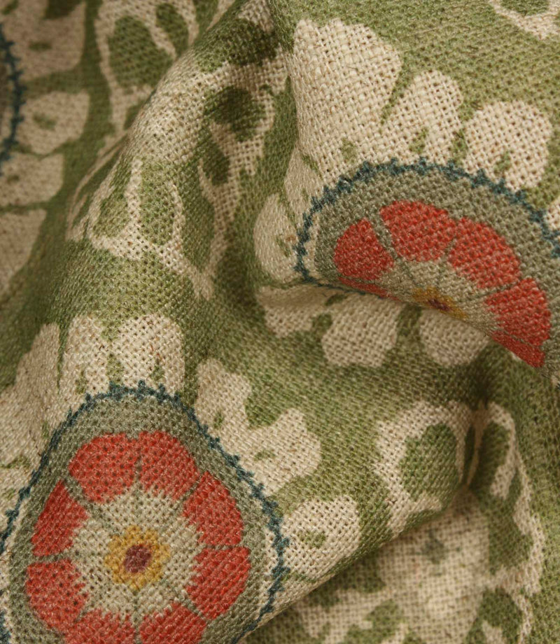 Detailed close-up of woven floral fabric in olive green, cream and coral tones, highlighting the textured linen-look finish.