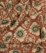 Draped terracotta floral fabric with soft natural texture and traditional decorative pattern.