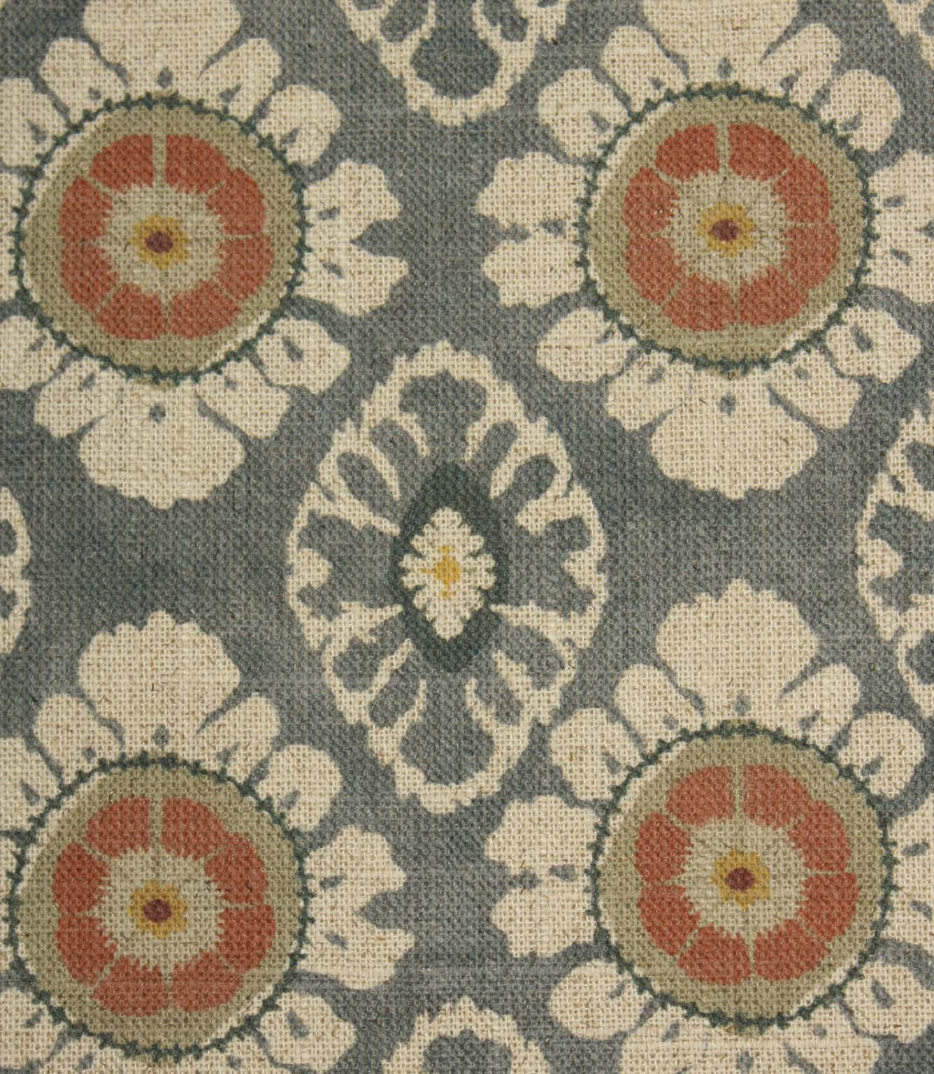 Close-up of blue grey vintage-style floral fabric with coral medallions and cream ornamental motifs.