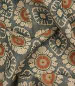 Draped blue grey decorative fabric with coral floral detailing and traditional repeating pattern.