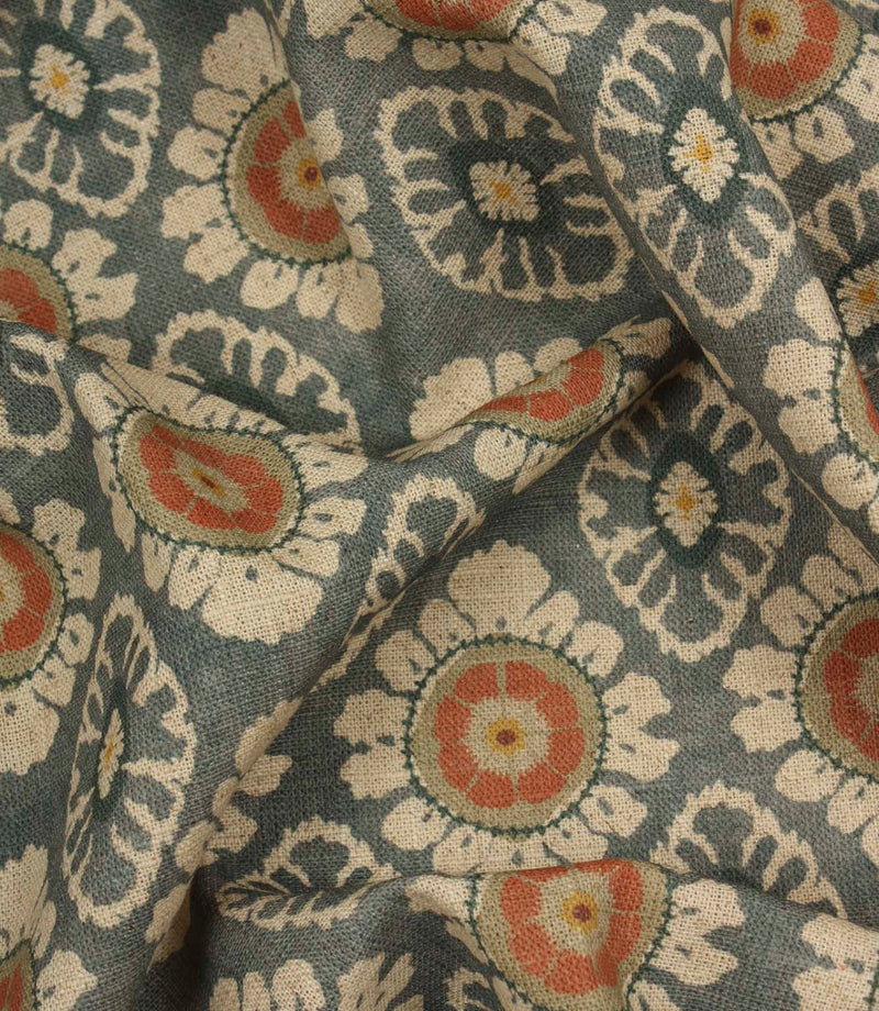 Draped blue grey decorative fabric with coral floral detailing and traditional repeating pattern.