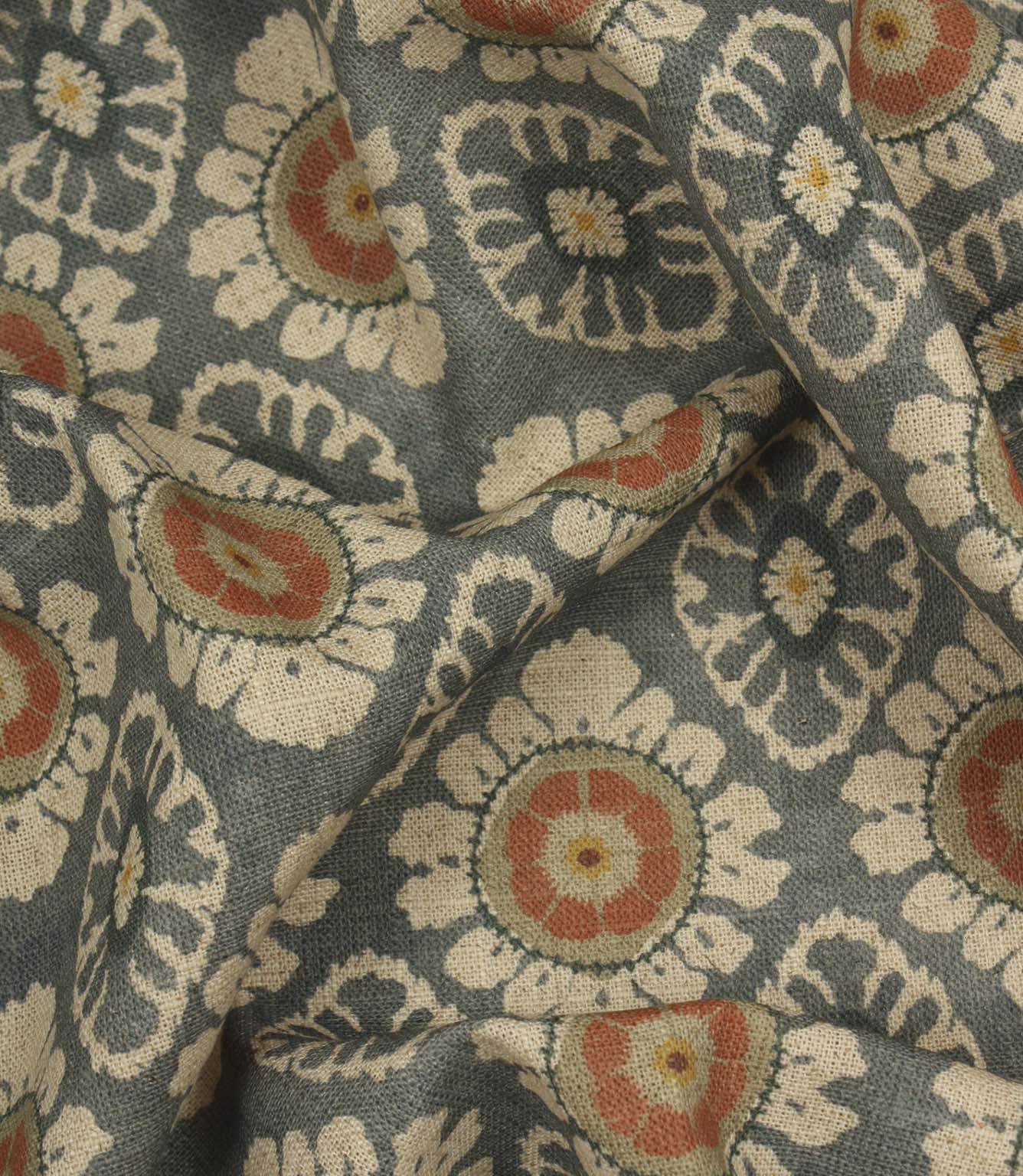 Draped blue grey decorative fabric with coral floral detailing and traditional repeating pattern.