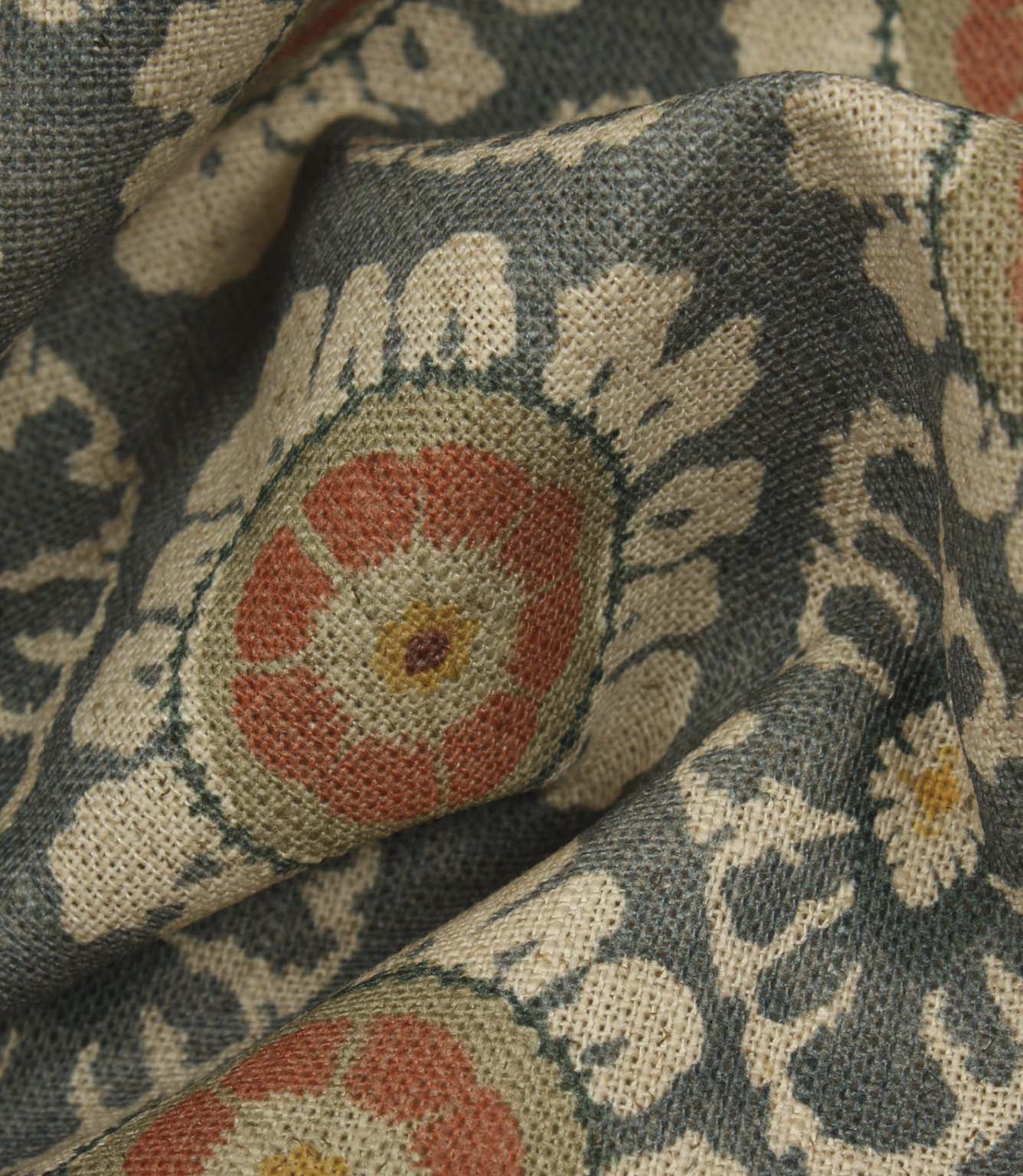 Detailed close-up of blue grey woven floral fabric, showing textured surface and stylised medallion design.