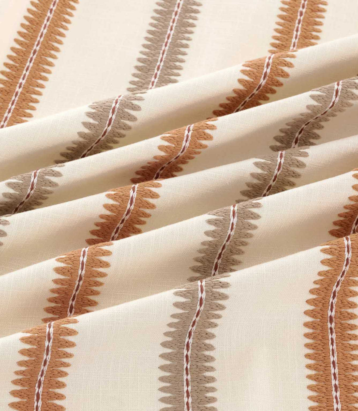 Close-up of Meschutt Coralee fabric draped in soft folds, highlighting raised terracotta and taupe embroidered stripes with zigzag edges and fine central stitching on ivory fabric.