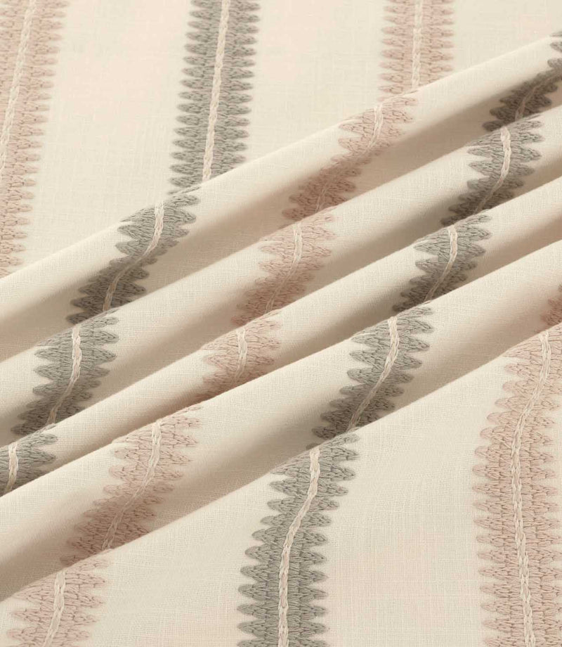 Close-up of Meschutt Oyster embroidered fabric arranged in soft folds, showing textured blush pink and grey-taupe vertical stripes with delicate central stitching on an ivory background.