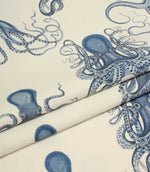 Folded ivory and blue octopus fabric showing the scale of the pattern and smooth woven texture.