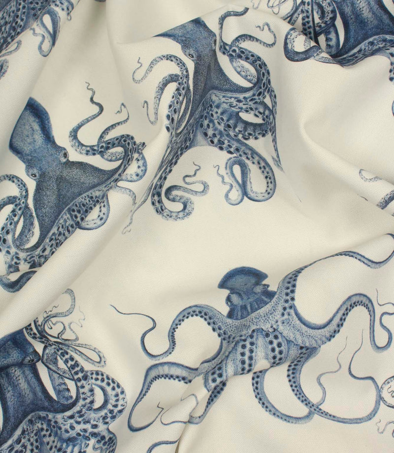 Draped nautical fabric with large illustrated octopus motifs in rich blue tones on an ivory background.