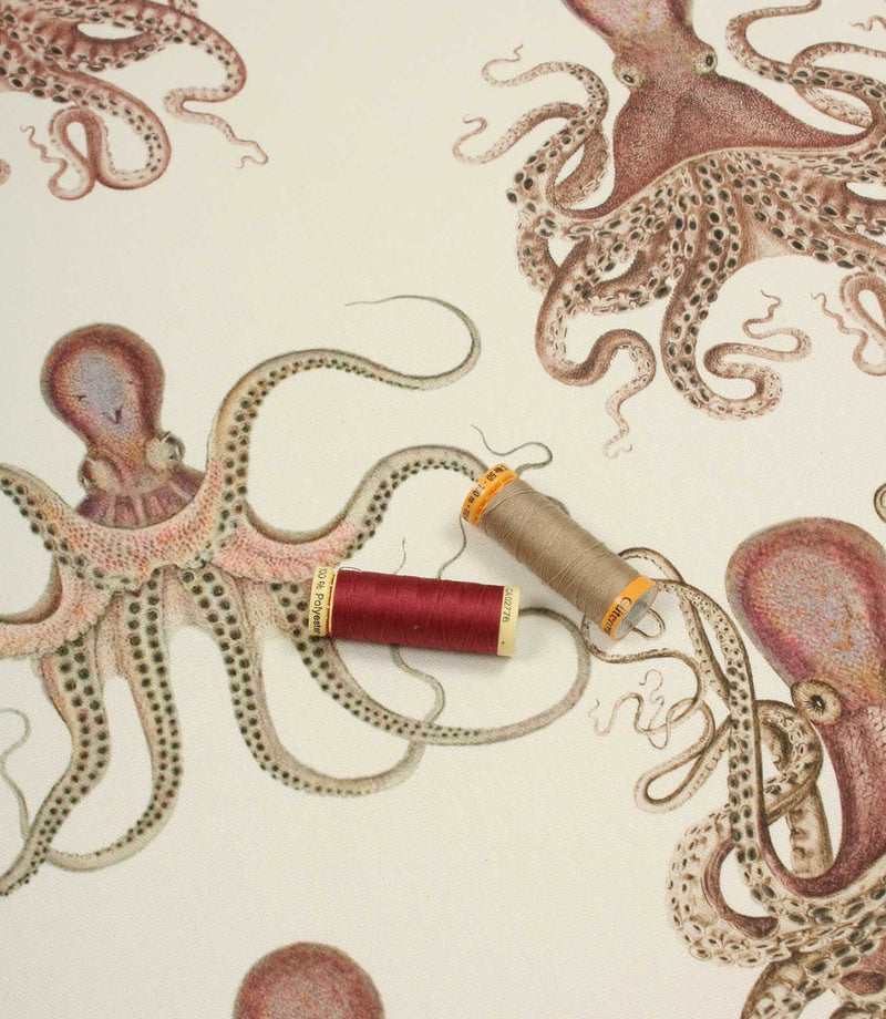 Illustration of octopuses and spools of thread on a beige background