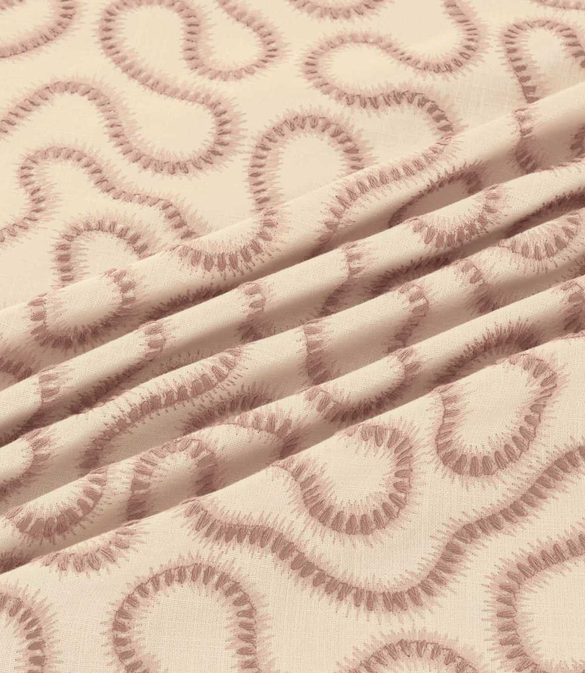 Orient Shell fabric gathered into soft folds, highlighting dusty pink embroidered flowing lines and the subtle texture of its ivory woven base.
