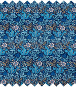 Close-up of woodblock floral fabric with an intricate navy blue background, turquoise and blue foliage, soft pink flowers and trailing gold leaves.