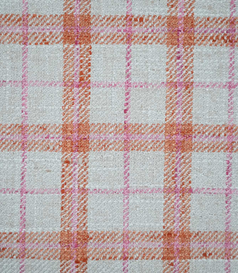 Close-up of Painswick Check Russett fabric showing a detailed woven check design with textured russet orange bands, delicate pink lines and a natural cream base, highlighting the interwoven yarns and subtle diagonal detailing.