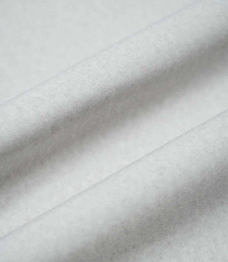 Palermo Marble fabric arranged in soft, flowing folds, showing its pale grey colour, gently textured surface and subtle variations in tone as the material catches the light.