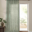Full-length Perrie Leaf sheer curtain in forest green and soft white, featuring a delicate trailing leaf pattern beside a bright glazed door.