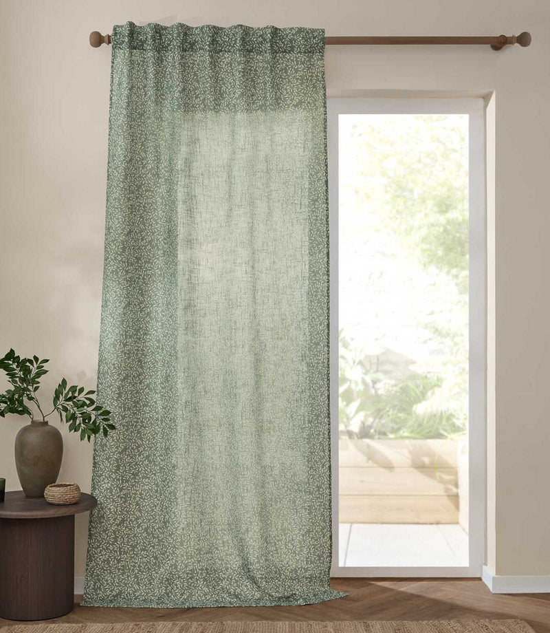 Full-length Perrie Leaf sheer curtain in forest green and soft white, featuring a delicate trailing leaf pattern beside a bright glazed door.