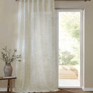 Full-length Perrie Leaf sheer curtain in natural cream and soft beige, featuring a delicate trailing leaf pattern and softly filtering daylight beside a glazed door.