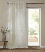 Full-length Perrie Leaf sheer curtain in natural cream and soft beige, featuring a delicate trailing leaf pattern and softly filtering daylight beside a glazed door.