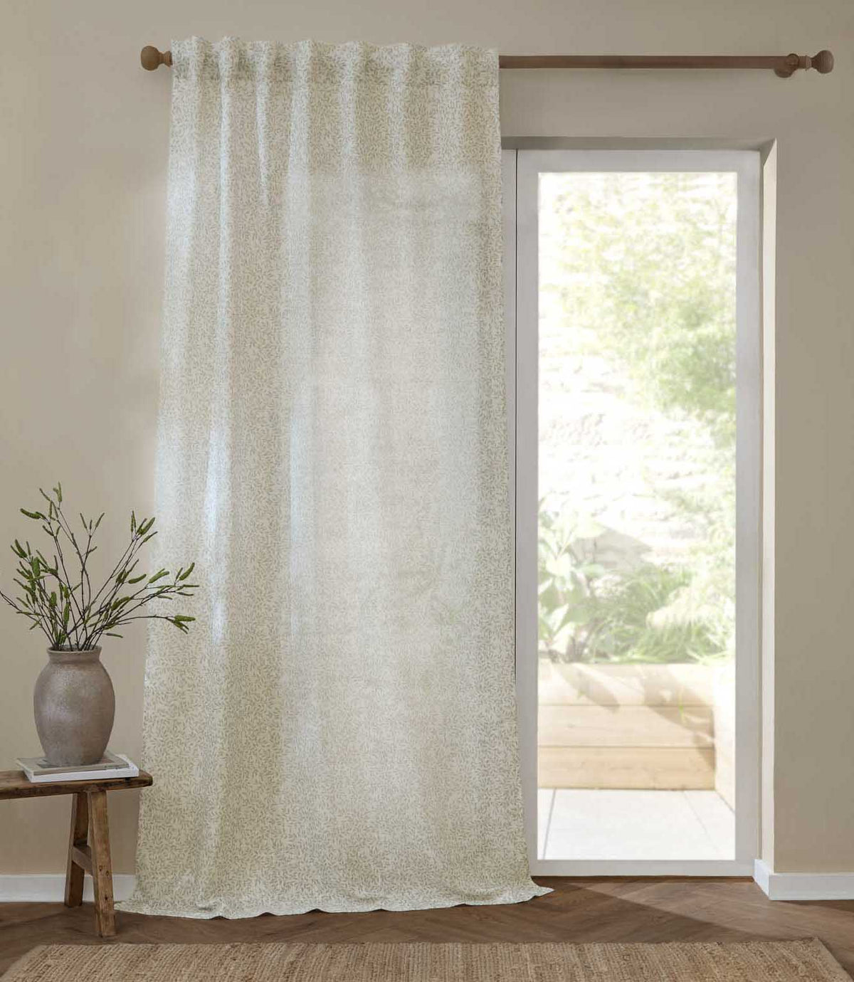 Full-length Perrie Leaf sheer curtain in natural cream and soft beige, featuring a delicate trailing leaf pattern and softly filtering daylight beside a glazed door.