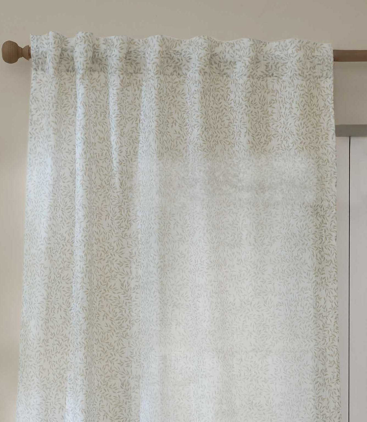 Close-up of Perrie Leaf sheer curtain in natural cream and beige, showing the gathered heading, lightweight fabric and small-scale leafy pattern.
