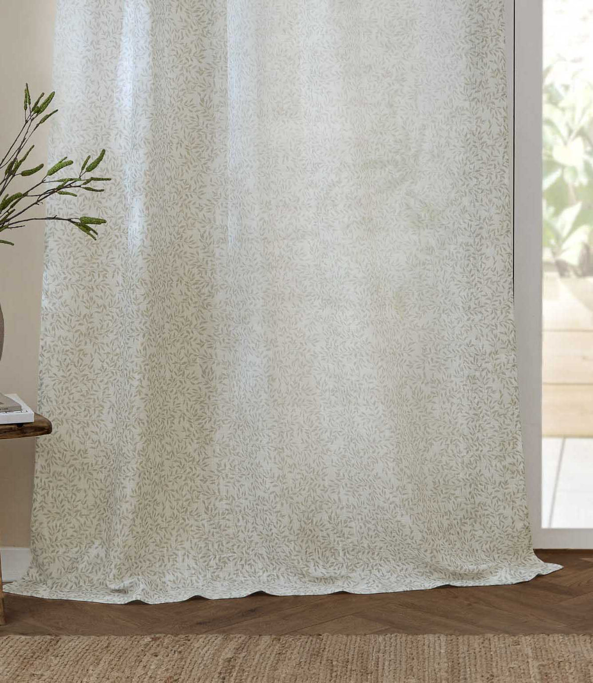 Full-length Perrie Leaf sheer curtain in natural cream and soft beige, showing the delicate leaf design and light-filtering fabric draping onto a wooden floor.