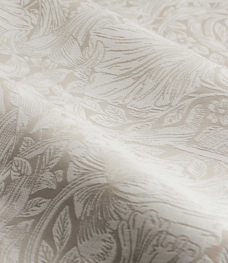 Close-up of Morris & Co Pimpernel jacquard fabric in cream and beige, showing the textured weave and detailed William Morris floral and foliage pattern.