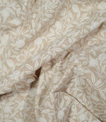 Draped Pomegranate Linen Look William Morris fabric in beige and cream, showing how the botanical design and linen-look texture appear in soft folds.