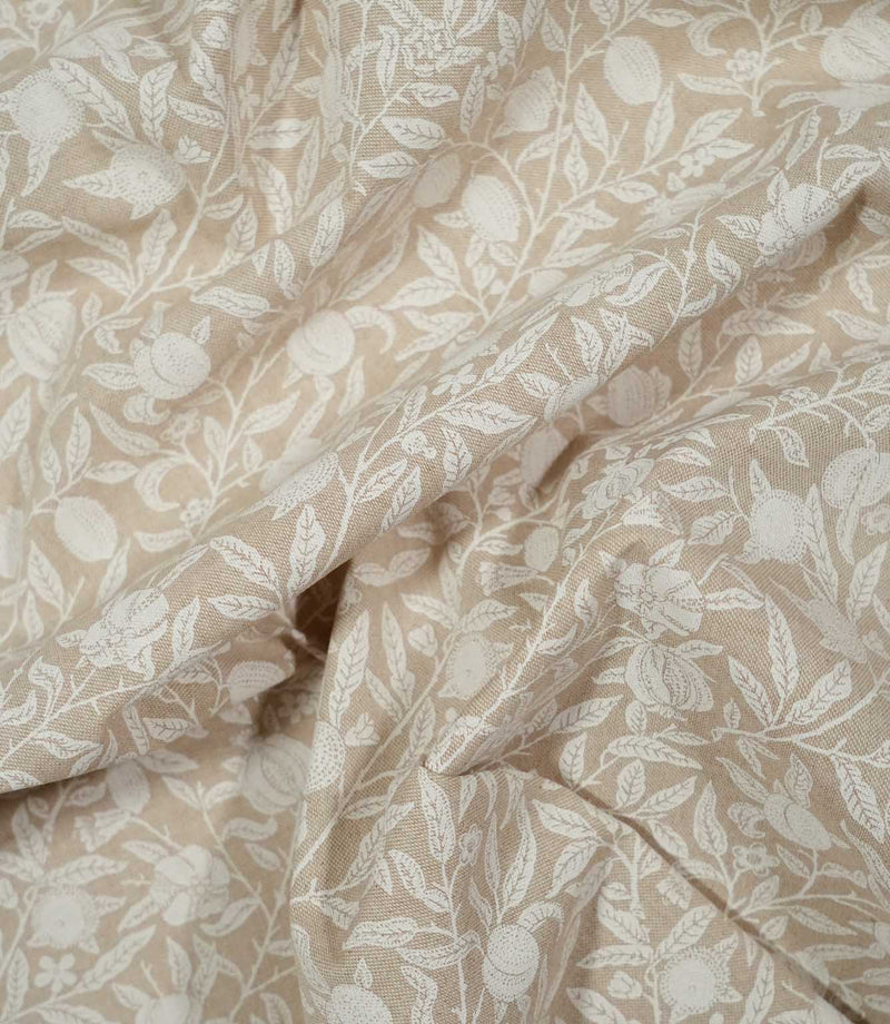 Draped Pomegranate Linen Look William Morris fabric in beige and cream, showing how the botanical design and linen-look texture appear in soft folds.