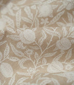 Detailed close-up of Pomegranate Linen Look William Morris fabric in warm beige and cream, highlighting the woven texture, pomegranates, flowers and leaves.