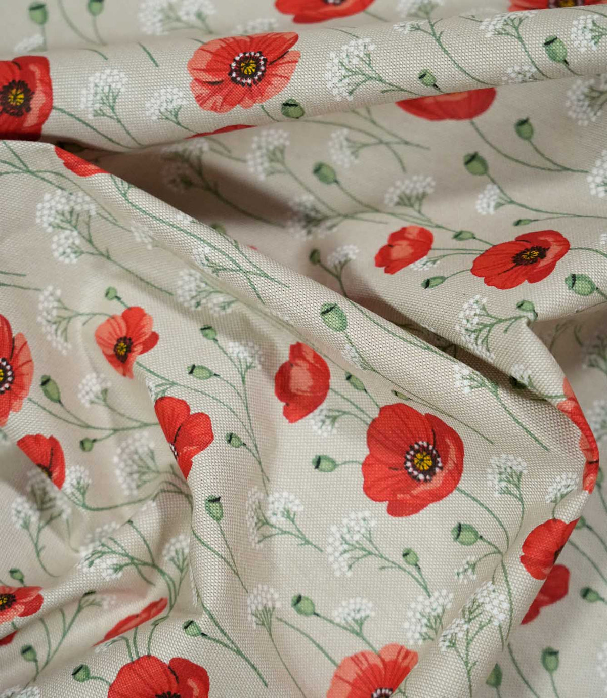 Poppy Trail Red fabric loosely draped into soft folds, featuring red and coral poppies, delicate green stems and white meadow flowers on a natural beige background.