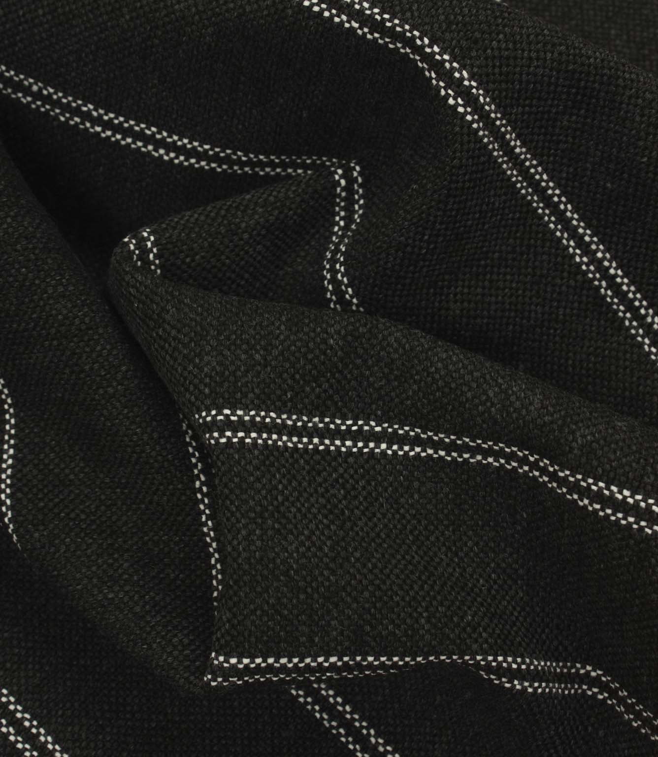 Draped black and white striped fabric with a heavyweight woven texture and soft structured folds.