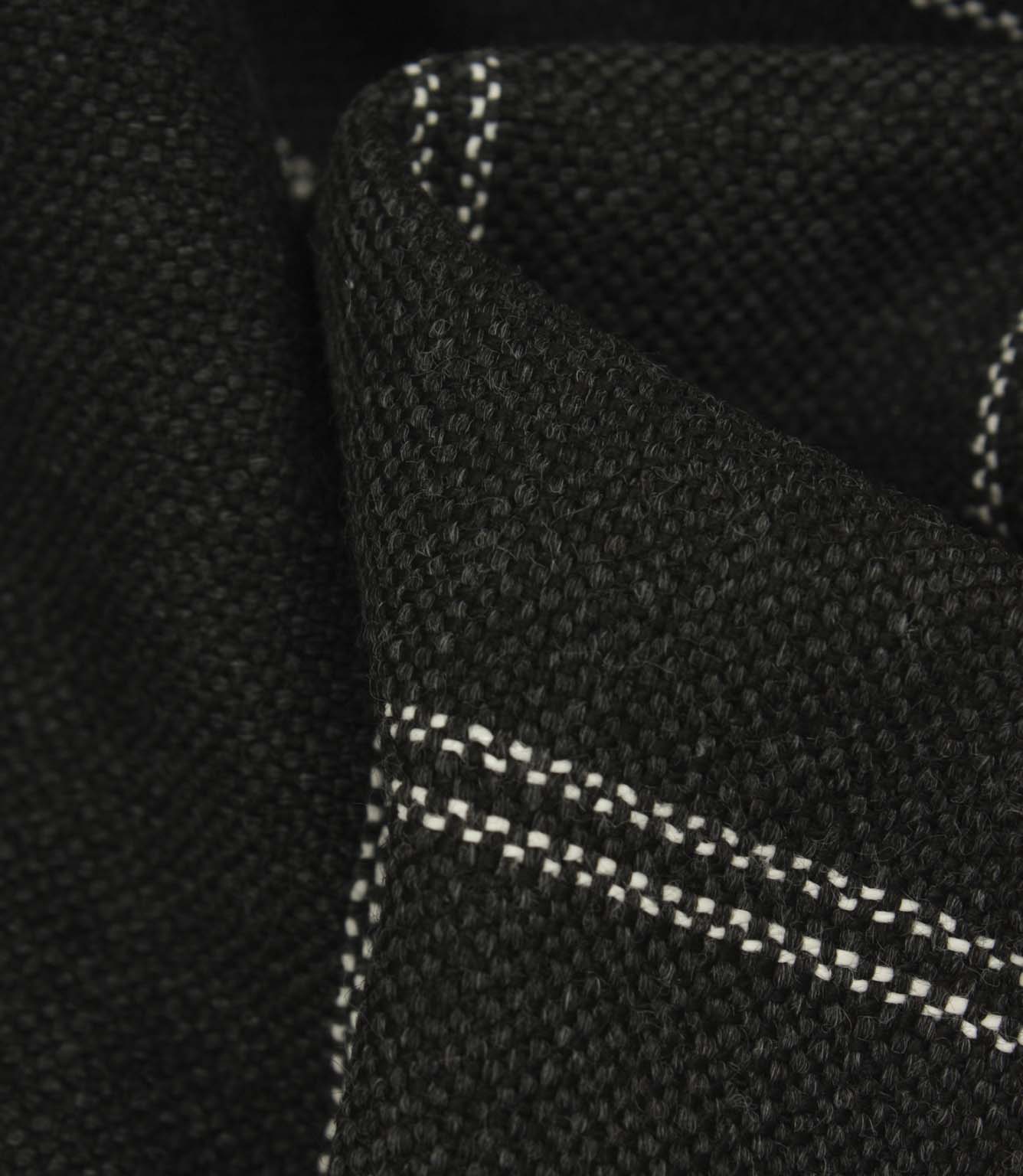 Macro detail of charcoal woven upholstery fabric with subtle white stitched stripe pattern and textured finish.