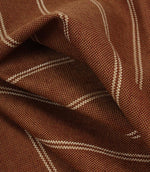 Draped copper brown woven fabric with delicate cream stripe pattern and soft flowing folds.