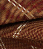 Macro detail of copper brown upholstery fabric showing the textured weave and subtle cream stitched stripes.