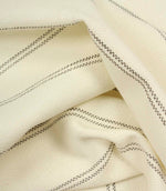 Draped ecru woven fabric with subtle grey stripe pattern and soft flowing folds.