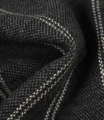 Macro detail of ink blue upholstery fabric showing the textured weave and subtle white stitched stripes.