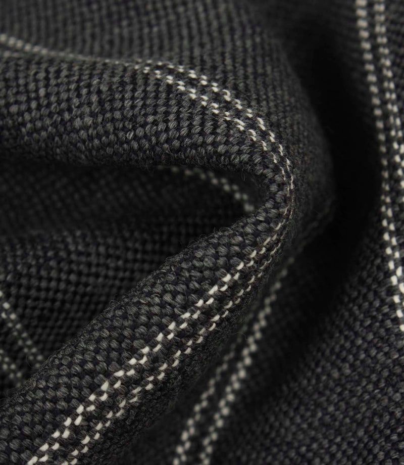 Macro detail of ink blue upholstery fabric showing the textured weave and subtle white stitched stripes.